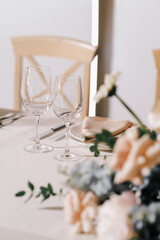 Wine glasses in the foreground. Wedding Banquet or gala dinner. The chairs and table for guests, served with cutlery and crockery.