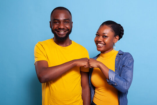 Portrait of cheerful people bumping fists together on camera, celebrating successful teamwork with agreement gesture. Girlfriend and boyfriend being partners and having achievement.