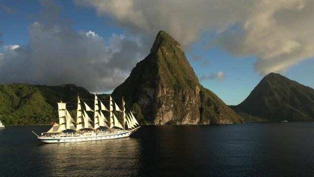 The Royal Clipper under full sails in front of Saint Lucia's iconic Pitons - side on view. Beautiful Sailing Ship in the Caribbean. Aerial perspective revealing mountains.