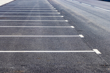 An empty parking lot in a residential area with yellow parking stops for cars. close-up. Stop Parking Limiter. © Anoo