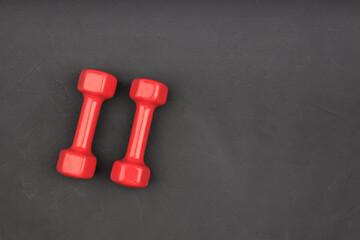 two red dumbbells on a black background