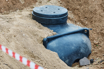 A cable underground well is installed in a pit and sprinkled with sand. New environmentally friendly material. Construction site area.