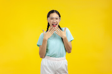 Surprised Young Asian Woman over isolated yellow background, summer photo concept