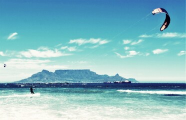 Fototapeta premium Landscape with kite surfer having fun on the Atlantic ocean and Table Mountain in the background mixed media