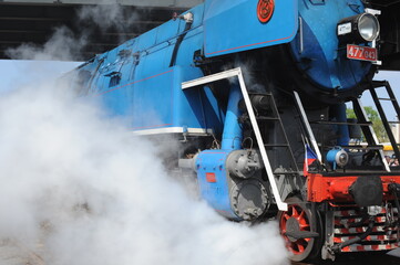 Antique powerful blue steam locomotive type ČSD Class 477.0 from Czech bursting steam and vapour in Wolsztyn, Poland