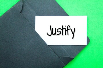 black envelope and white paper with the word Justify - obrazy, fototapety, plakaty