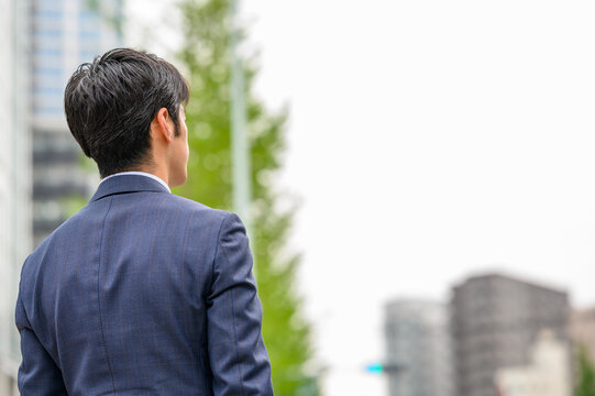 都会に佇むビジネスマン　後ろ姿　ポートレート