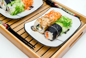 Several sushi on a white plate standing on a white background
