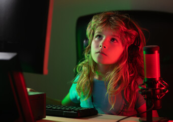 Child with pc computer at night. Overuse and addiction kids from gadgets. School, study, online learning concept. Schoolboy typing on keyboard.