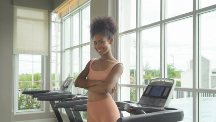 Fototapeta premium Portrait of Black African American woman at gym fitness center club. Muscle strength training workout. Exercise indoor with sport equipment. Athletic. People lifestyle. Recreation.