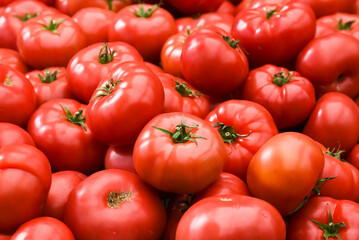 Tomatoes stacked on top of each other in a supermarket for sale, tomato texture.