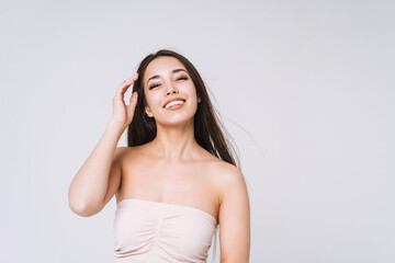 Fototapeta premium Beauty portrait of happy young beautiful asian woman with healthy dark long hair in top bando on white background isolated