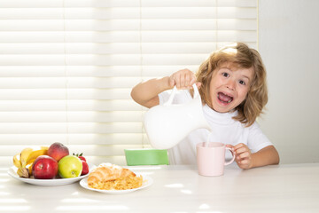 Fuuny excited little boy pouring whole cows milk for breakfast. Schoolkid eating breakfast before school. Portrait of child sit at desk at home kitchen have delicious tasty nutritious breakfast.