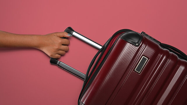 Woman with suitcase on pink background, ready for summer holidays. Top view with copy space