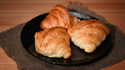 Fresh baked croissant on wooden table for homemade breakfast