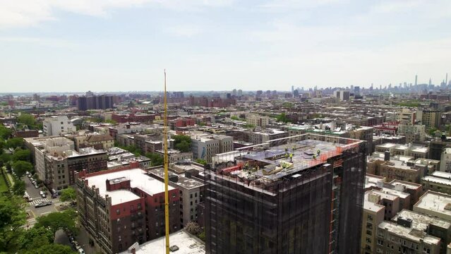 360 panning drone shot of Manhattan construction project, NYC skyline in background