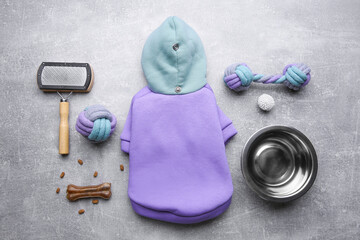 Flat lay composition with dog clothes, food and accessories on grey table