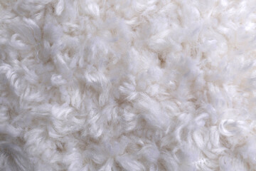 Soft white knitted fabric as background, top view