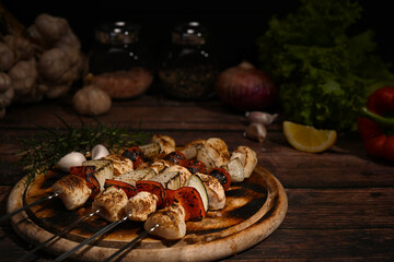 Close up tasty grilled chicken skewers with tomato, sweet pepper and onions on cutting board ready to serve