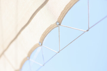 Beach umbrella on stretched rope closeup. Quality parasol - obrazy, fototapety, plakaty