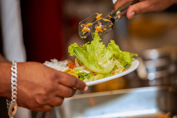 close up of a person holding a bowl of salad