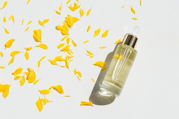 Transparent bottle with dropper pipette with serum or essential oil with beautiful yellow flowers....