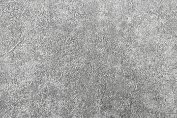 Gray background of decorative plaster with abstract spots. Unusual silver wall texture with beautiful patterns, creative surface background. Dressing coating for building cladding.