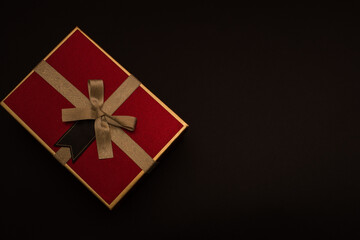 red box with gold ornament on black background top view with place for text, black friday discount concept, black friday sale