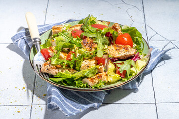 Healthy balanced diet food. Green salad with grill chicken breast fillet, tomatoes, olive oil top view copy space