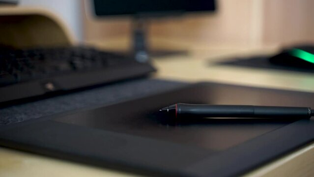 Close-up of hand drawing on a digital tablet with pen. Professional retoucher working on graphic tablet.
