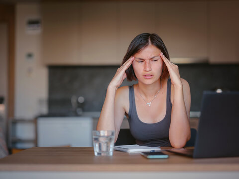 Frustrated sad woman feeling tired, worried about problem sitting at laptop, depressed girl worried about reading bad news online, debt notification email or negative message