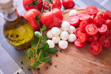 Ingredients for Caprese salad - Mini mozzarella cheese in glass bowl, tomato and basil