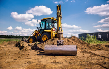 Excavator working at house construction site - digging foundations for modern house. Beginning of...