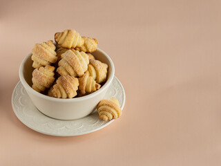 Pastry rolls. Mini cottage cheese croissants. Bagels with sugar in the white ceramic bowl on the coral linen kitchen towel the milky color ceramic bowl.