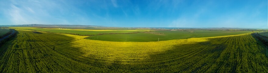 Panorama of the fields with a plant in a valley against the background of the village and the sky in Bulgaria