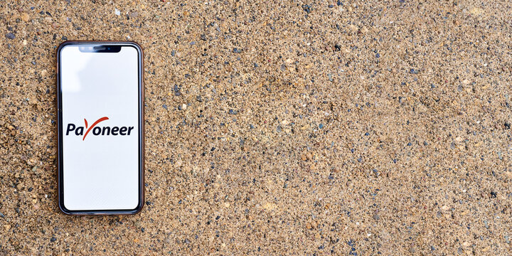 Ukraine, Kyiv, May 3, 2022 - Smartphone with payoneer logo lies on the sand. payoneer logo. Banner.