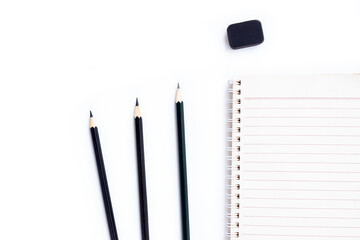 Notebook , Black pencils and black eraser isolated on white background