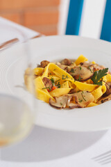 Porcini tagliatelle, a variety of pasta with mushroom, and a glass of wine