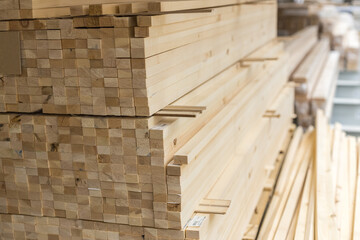 Wooden long rectangular bars in a stack. Dry planed block made of solid wood for construction....