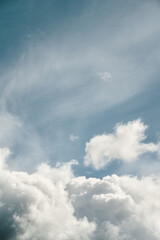 Distant white clouds in the sky during a sunny day in summer