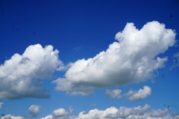 Naklejka na ściany i meble Weißes Wolkengebilde am blauen Himmel bei Sonne im Frühling 