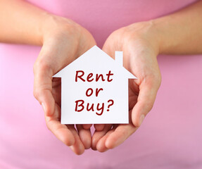 Hands of woman holding paper house with rent or buy text