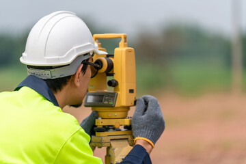 Surveyor Civil Engineer working theodolite or total positioning station on the construction site of...