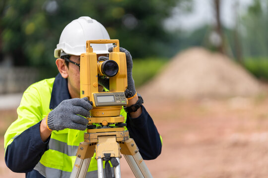 Surveyor Civil Engineer using equipment theodolite or total positioning station on the construction site.