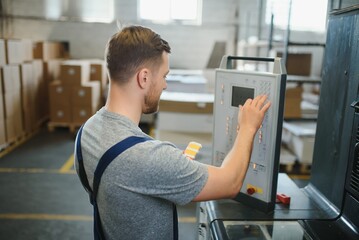 Man working in printing house with paper and paints