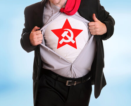 Young angry businessman tearing his shirt communist symbol hammer and sicke on it  