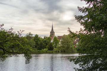 Fototapeta na wymiar View over Klostersee lake in Sindelfingen, Germany, with old church tower in the middle of the photo.