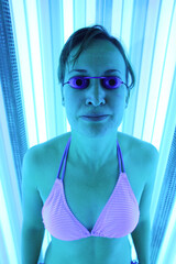 Young woman tanning in solarium