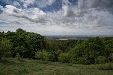 Fototapeta na wymiar British hillside view over Worcestershire with trees and meadows under a cloudy sky