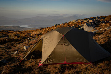 An explorers tent on a mountain with beautiful rural background 